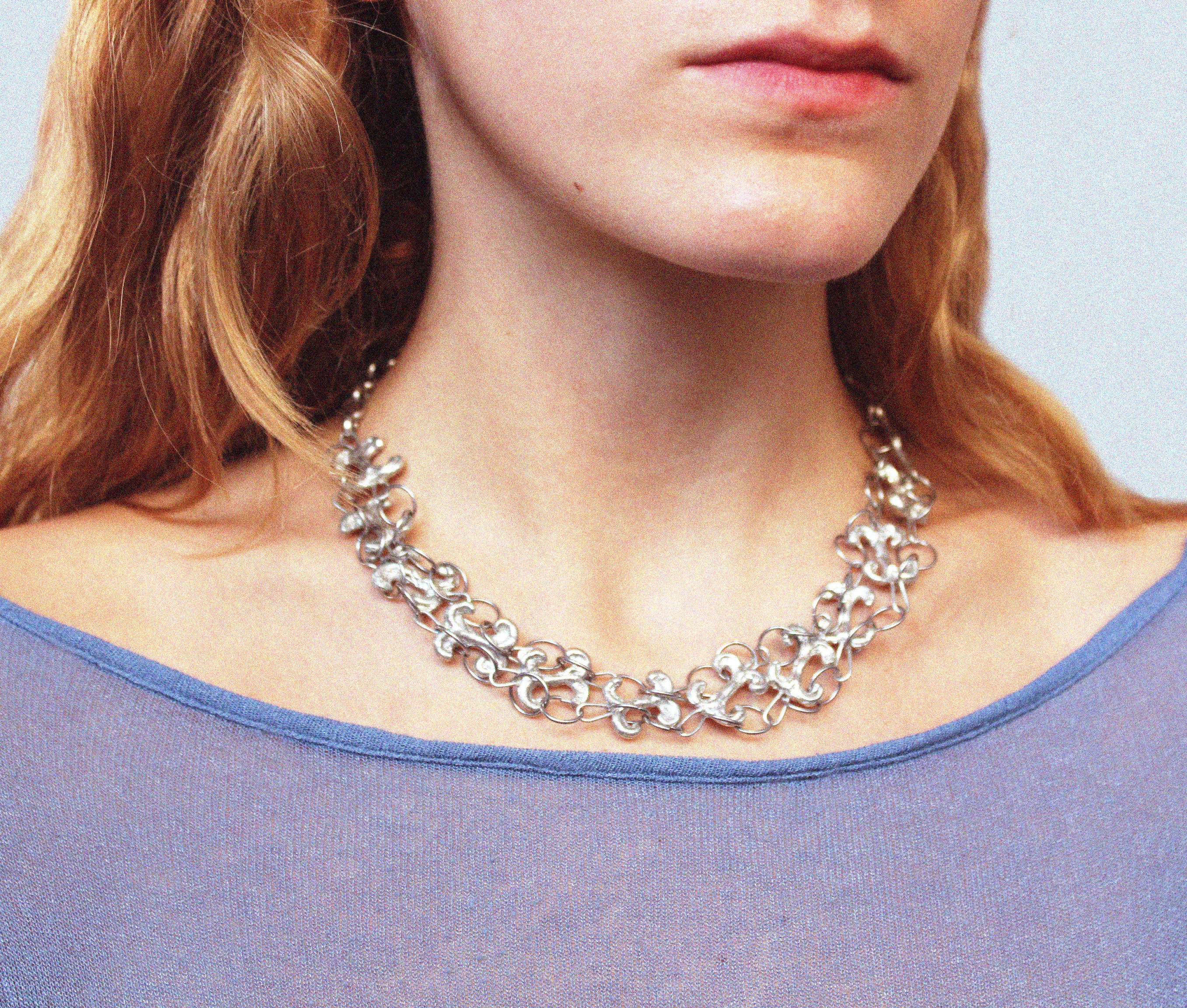 Close up collier double volute porté long en étain fondu à la main selon un procédé artisanal unique établi par la marque Lolie