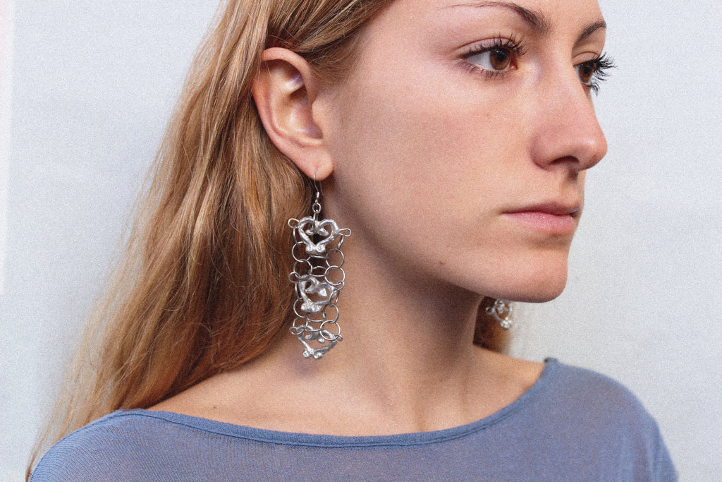 Close up boucles d'oreilles "orbevoie coeur" inspirées de la ferronnerie d'art avec pendentifs fondus individuellement selon un procédé artisanal unique mis au point par la marque de bijoux Lolie, finition argenté