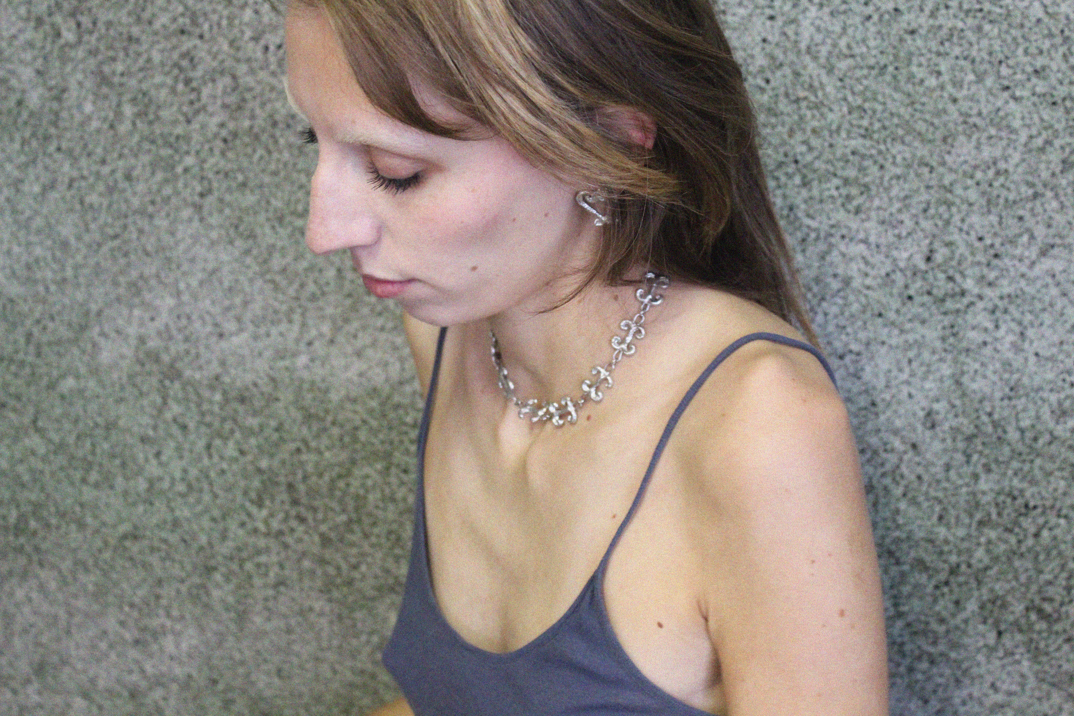 shooting éditorial collier inspiré de la ferronnerie d'art avec pendentifs "volute" fondus individuellement selon un procédé artisanal unique mis au point par la marque de bijoux Lolie, finition argenté, tissu organza lavande