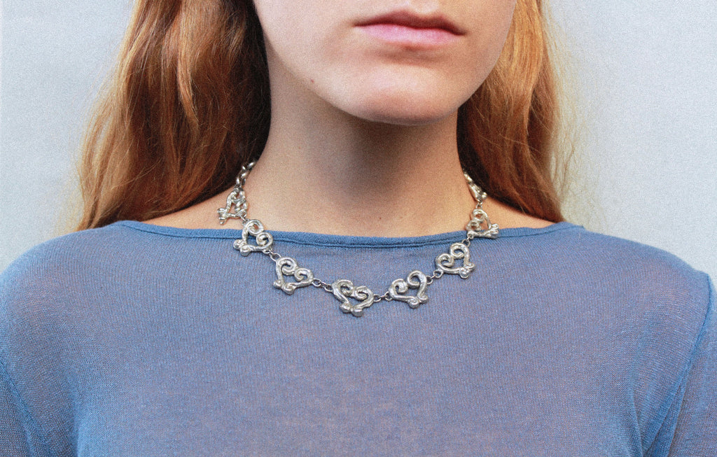 close up collier coeur en étain argenté fondu individuellement à la commande selon un procédé artisanal unique mis en place par la marque de bijoux Lolie