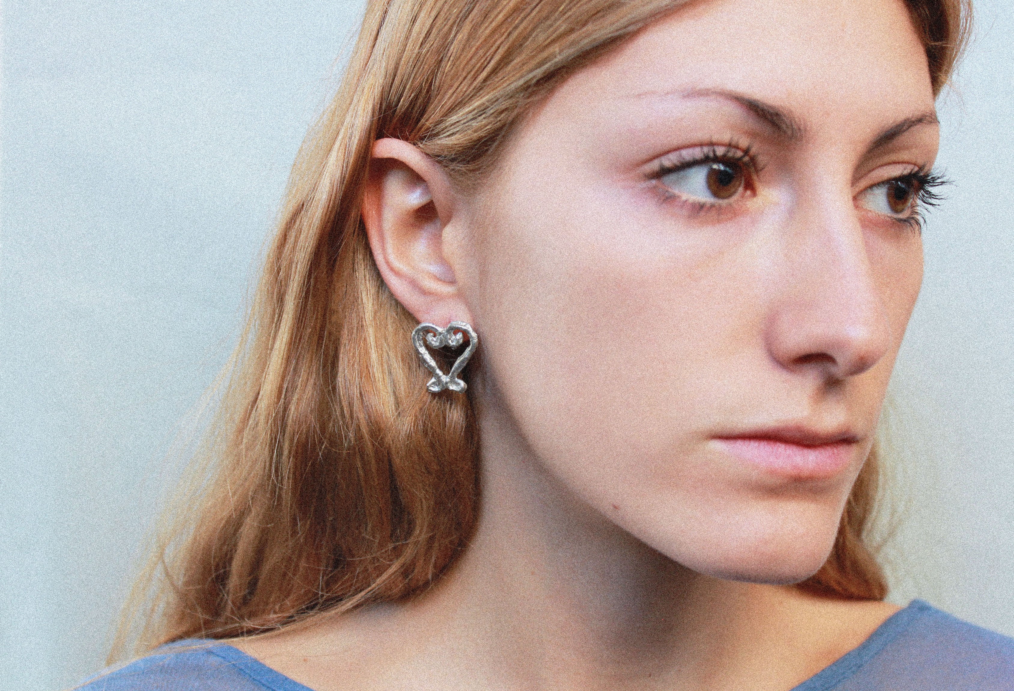 close up boucles d'oreilles coeur en étain argenté fondu individuellement à la commande selon un procédé artisanal unique mis en place par la marque de bijoux Lolie