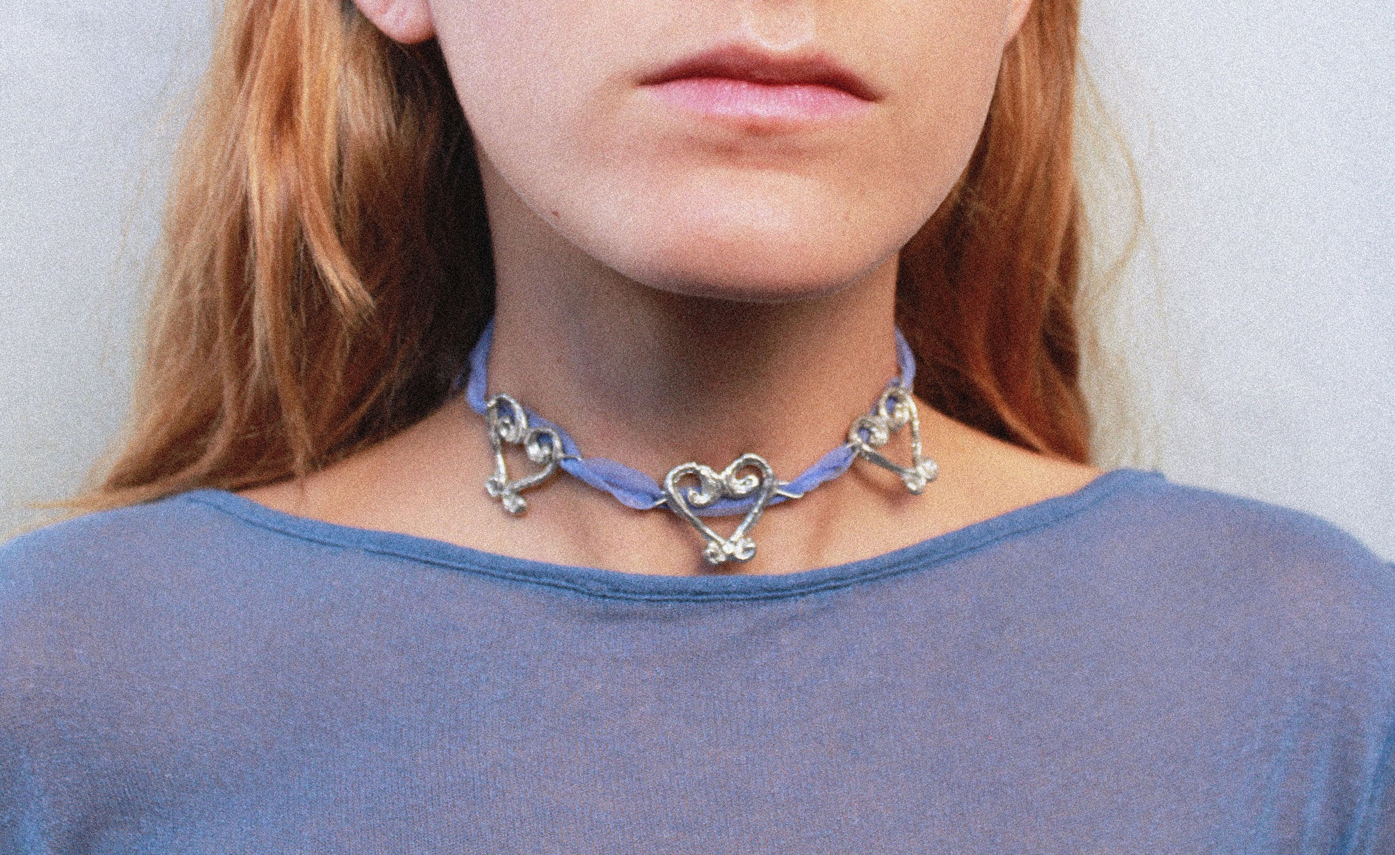 Close up collier organza et pendentifs coeurs fondus individuellement selon un procédé artisanal unique mis au point par la marque de bijoux Lolie, finition argenté, tissu organza lavande