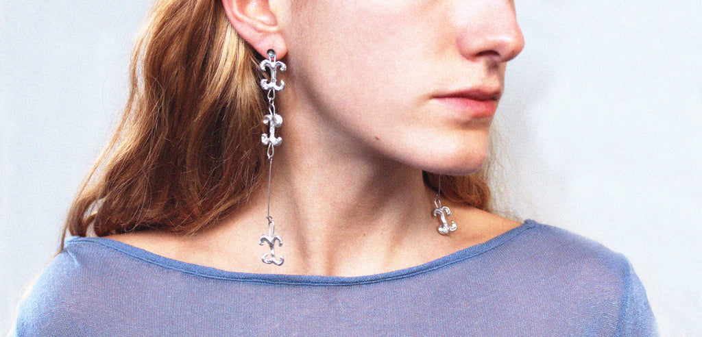 Close up boucles d'oreilles uniques triple volute en étain fondu artisanalement à Paris