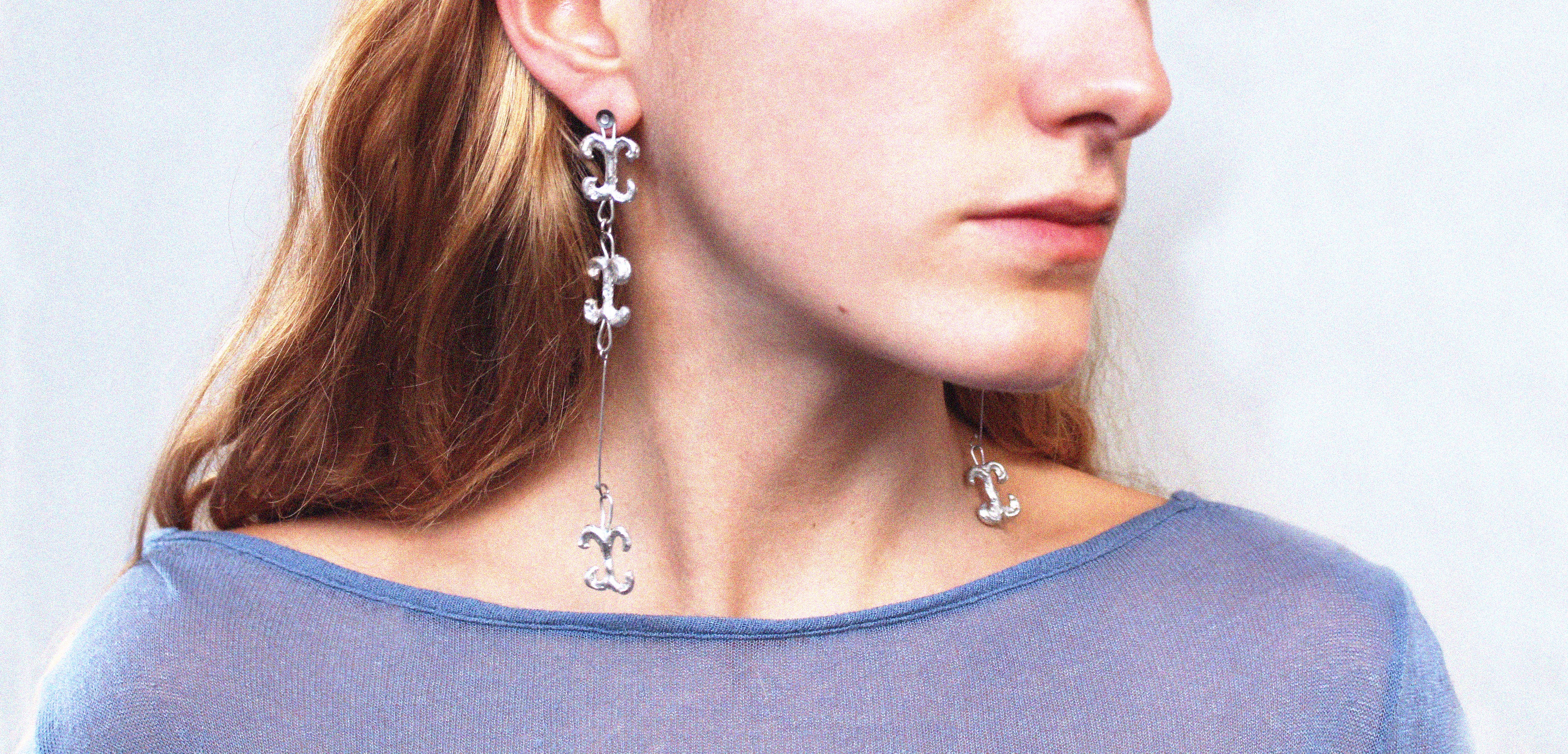 Close up boucles d'oreilles uniques triple volute en étain fondu artisanalement à Paris